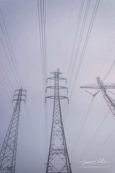 JCCI-100609 - Towering electrical power pylons disappearing into thick fog portrait