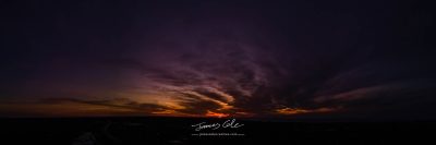 JCCI-100636 - Dark wispy clouds in a deep purple sky in the afterglow of an orange sunset aerial panoramic