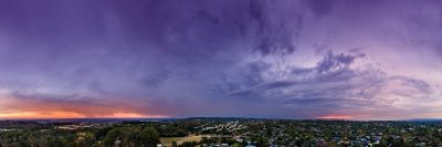 JCCI-100641 - Stormy rain clouds in the afterglow of sunset glowing purple, blue and orange aerial panoramic